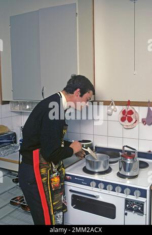Carl XVI Gustaf, König von Schweden. Geboren am 30. april 1946. Als Kronprinz in seiner Studentenwohnung und Küche, während er in Uppsala studiert. Er steht neben dem Küchenherd und trägt eine Schürze und gibt vor, etwas zu kochen, aber es gibt kein Essen im Kochtopf. 1968 Stockfoto