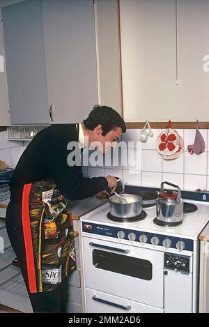 Carl XVI Gustaf, König von Schweden. Geboren am 30. april 1946. Als Kronprinz in seiner Studentenwohnung und Küche, während er in Uppsala studiert. Er steht neben dem Küchenherd und trägt eine Schürze und gibt vor, etwas zu kochen, aber es gibt kein Essen im Kochtopf. 1968 Stockfoto