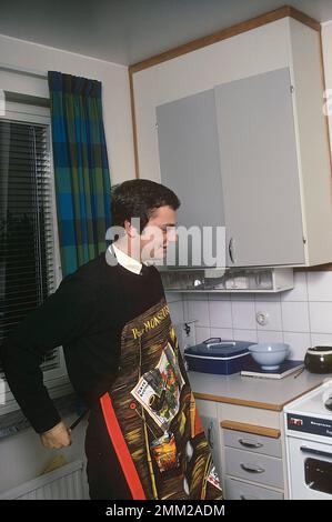 Carl XVI Gustaf, König von Schweden. Geboren am 30. april 1946. Als Kronprinz in seiner Studentenwohnung und Küche, während er in Uppsala studiert. Er steht neben dem Küchenherd und trägt eine Schürze und gibt vor, etwas zu kochen, aber es gibt kein Essen im Kochtopf. 1968 Stockfoto