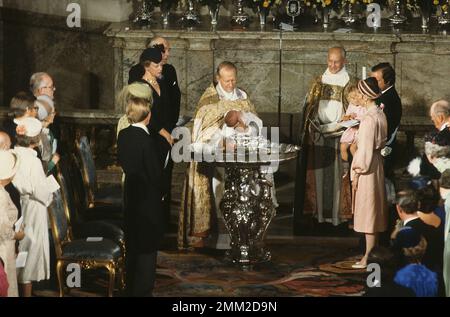 Carl XVI Gustaf, König von Schweden. Geboren am 30. april 1946. Die Taufe von Prinz Carl Philip. König Carl, der XVI. Gustaf, mit Ehefrau Königin Silvia und Kronprinzessin Victoria in der Burgkirche am 31. August 1979. Silvia hält Prinz Carl-Philip während seiner Taufe, die von Erzbischof Olof Sundby und Hans Åkerhielm durchgeführt wurde, in ihren Armen. 1979 Stockfoto