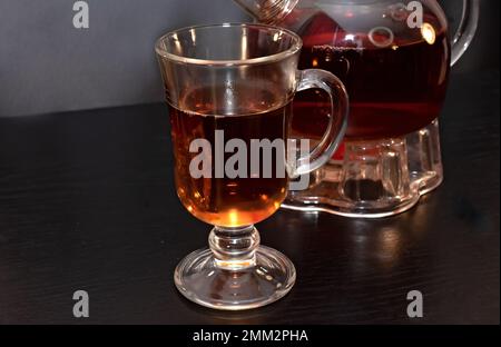 Tee in einem großen Glas und Teekanne Stockfoto