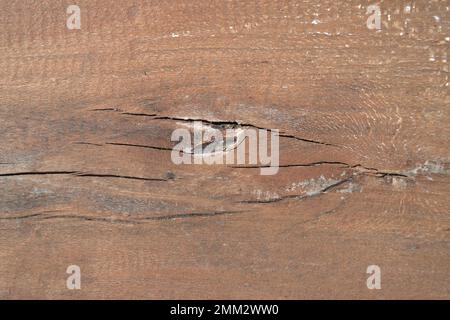 Abstrakter Hintergrund aus braunem rotem Holz mit Holzmöbelflecken mit Rissen und Knoten für Tisch oder Stuhl. Stockfoto