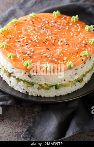 Lachs-Sushi-Kuchenrolle auf dem Teller auf dem Tisch. Vertikal Stockfoto
