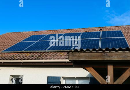 Auf dem Dach eines Hauses installierte Photovoltaikpaneele Sonnenkollektoren auf einem Dach. Stockfoto