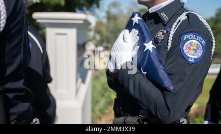 Ein Mitglied der Ehrengarde der Polizeibehörde Mandeville hält eine amerikanische Flagge, bevor in Mandeville, Louisiana, am 14. September 2022, ein permanentes Denkmal für den Mandeville Polizeihauptmann Vincent Liberto Jr. enthüllt wird. Liberto diente 10 Jahre in der US Marine Corps Reserve, bevor er ehrenhaft als Sergeant entlassen wurde. Er wurde am 20. September 2019 in der Dienstlinie angeschossen und getötet. An der Einweihung im Namen des Marine Corps nahm der US Marine Corps Col. Justin Ansel, stellvertretender Stabschef der Marine Forces Reserve G-3/5 und Bewohner von Mandeville Teil. . „Wir als Offiziere sind es Ameri schuldig Stockfoto