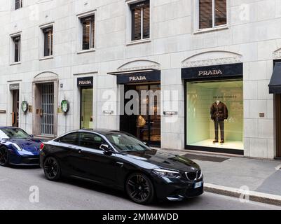 Mailand, Italien - Ottobre 16, 2022: BMW-Auto neben dem Prada-Geschäft in Montenapoleone. Mailand ist ein luxuriöses Modeziel für die neuesten High-e-Modelle Stockfoto