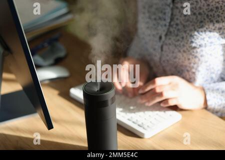 Modernes Luftbefeuchtergerät in der Nahaufnahme des Büroarbeitsplatzes. Stockfoto