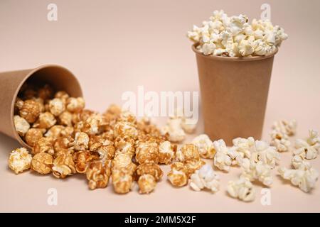 Zwei Arten Popcorn in zwei Pappbechern. Сaramel-gedecktes und gesalzenes Popcorn. Geringe Schärfentiefe. Stockfoto