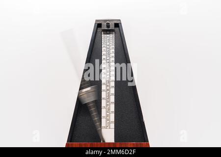 Altmodisches Metronom mit verschwommenem Arm, das Bewegungen auf weißem Hintergrund anzeigt Stockfoto