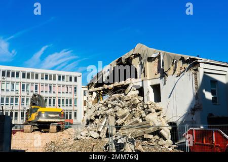 Abriss des alten Gebäudes mit Sloopkraan gegen den blauen Wolkenhimmel. Stockfoto