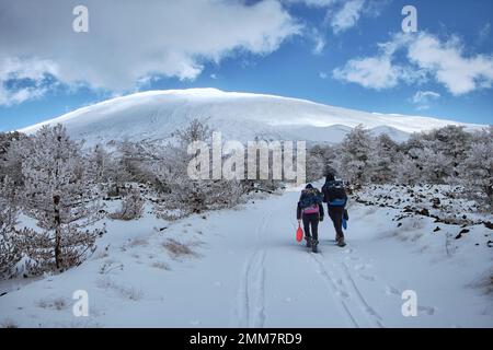 Wandern Sie auf einem schneebedeckten Pfad zum Ätna-Nationalpark in Sizilien, Italien Stockfoto