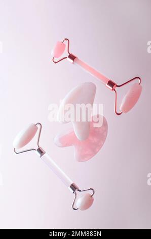 Rose Quartz Roller und Gua Sha Tool, Gesichtslifter-Kratzer-Massagebehandlung Stockfoto