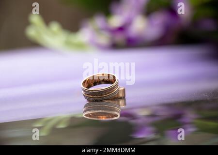 Zwei goldene Hochzeit Ringe auf dunklem Spiegelhintergrund, goldene Hochzeit Ringe, Hochzeit Stockfoto