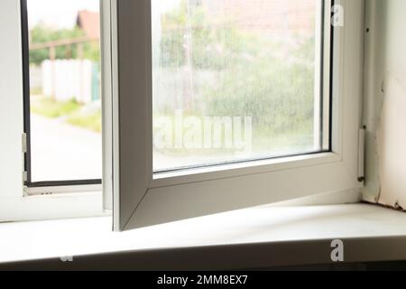 Schmutziges Fenster mit einer Schwelle mit Schimmel von Feuchtigkeit, Pilz auf dem Fenster in der Wohnung, reparieren Stockfoto