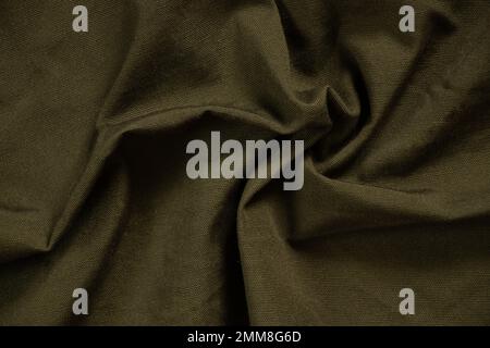 Dunkelgrüner, zerknitterter Stoff als Hintergrund, grüner Stoff Stockfoto