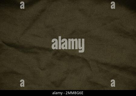 Dunkelgrüner, zerknitterter Stoff als Hintergrund, grüner Stoff Stockfoto