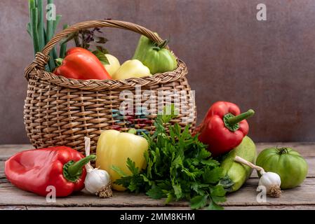 Korb aus Korb mit verschiedenen frischen Gemüsesorten auf einem Holztisch. Selektiver Fokus. Stockfoto