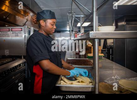 220915-N-RU001-1023 SAN DIEGO (SEPT 15, 2022) kulinarische Spezialistin Seaman Apprentice Amari Eliacin, gebürtig aus Miami, Florida, bereitet während eines hispanischen Heritage Month-Festes an Bord eines nicht selbstfahrenden Kasernen-Schiffs der APL-Klasse (APL 65), Sept. 15, Speisen zu. Der Flugzeugträger USS Carl Vinson (CVN 70) der Nimitz-Klasse befindet sich derzeit in seinem Heimathafen San Diego. Stockfoto