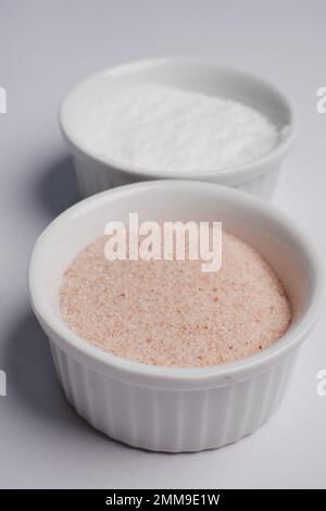 Rohes, vollgetrocknetes rosa Himalaya-Salz in einem Behälter auf weiß Stockfoto