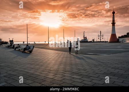 Willy-Brandt-Platz mit Leuchtturm Unterfeuer bei Sonnenuntergang, Hintergrundbeleuchtung, Strandkai, Havenwelten, Bremerhaven, Bremen, Deutschland Stockfoto