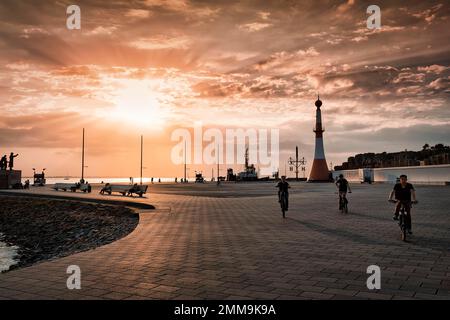 Willy-Brandt-Platz mit Leuchtturm Unterfeuer bei Sonnenuntergang, Hintergrundbeleuchtung, New Harbour, Havenwelten, Bremerhaven, Bremen, Deutschland Stockfoto