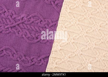 Lila- und beigefarbener Strickhintergrund. Großer Strickstoff mit Muster. Nahaufnahme einer Strickdecke. Stockfoto