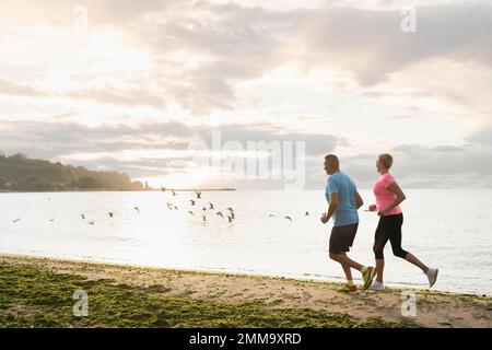 Seitenblick Älteres Paar Jogging Strand. Schönes Foto Stockfoto