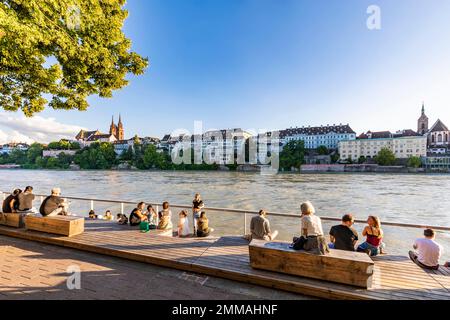 Menschen auf der Rheinterrasse am Rheinufer, Basler Dom, Rhein, Stadtblick, Basel, Kanton Basel-City, Schweiz Stockfoto