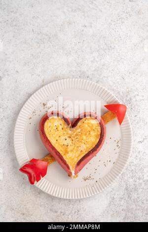 Romantisches Frühstück. Spiegeleier in herzförmigen Würstchen Stockfoto