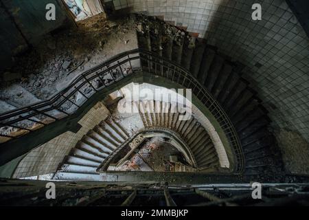 Alte Wendeltreppe im alten verlassenen Gebäude, Blick von oben. Stockfoto