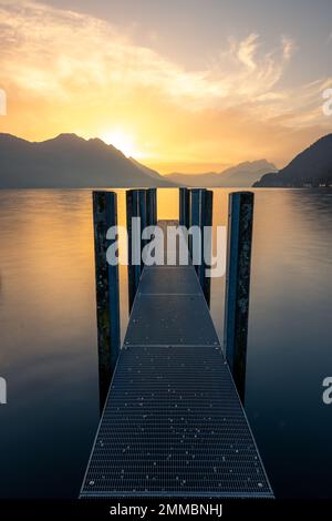 Ein Steg auf dem See während eines goldenen Sonnenuntergangs Stockfoto