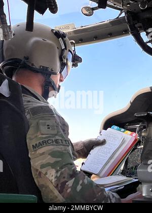 US Army Chief Warrant Officer 2 James Marchetti, gebürtiger aus Troy, NY, und UH-60m Black Hawk Pilot for A Company, 3-142. das Assault Helicopter Bataillon (AHB) aus Latham, New York, liest sich während der Inbetriebnahme eines UH-60m Black Hawk in Camp Buehring, Kuwait, 16. September 2022 aus einer Checkliste. Marchetti und seine Crew haben während ihres Fluges Landezonen in der Nähe des Camp Buehring untersucht. 3-142. AHB, der 36. Combat Aviation Brigade beigetreten ist, unterstützt derzeit die kombinierte Joint Task Force - Operation Inhärent Resolve Mission zur Beratung, Unterstützung und Ermöglichung von gemeinsamen Kräften in der e Stockfoto