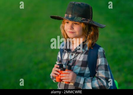 Kindertouristen mit Rucksäcken. Abenteuer-, Reise- und Tourismuskonzept. Ein Kind, das mit Rucksäcken in der Natur spaziert. Kleiner Entdecker auf der Reise. Stockfoto