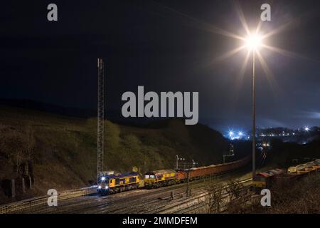 GB Rail Freight und DB Cargo Rail Klasse 66 Lokomotiven mit Güterzügen, die Steinbrüche in Peak Forest, Derbyshire, befördern Stockfoto