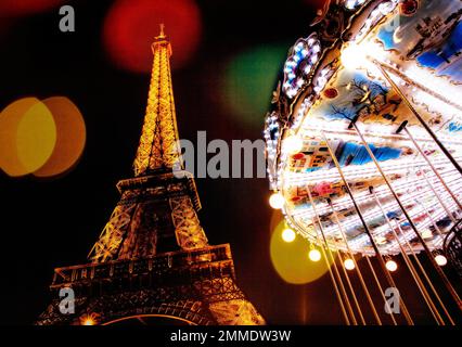 Das Karussell in der Nähe des voll beleuchteten Eiffelturms schafft eine festliche Atmosphäre in Paris, Frankreich. Stockfoto