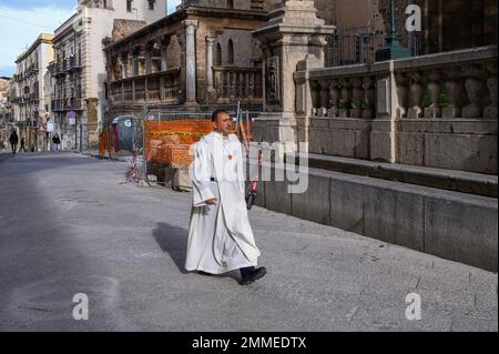 Palermo, Sizilien, Italien. 17. Januar 2023. Ein Mann mit Pfarrer-Uniform geht während der offiziellen Beerdigung des verstorbenen Missionars Biagio Conte vor die Kathedrale. Offizielle Beerdigung des Laienmissionars Biagio Conte, der am 12. Januar 2023 starb. Die Feier für den Gründer der Hope and Charity Mission (Missione Speranza e CaritÃ ) für Arme und Obdachlosigkeit in Palermo fand in der Kathedrale „Santa Vergine Maria Assunta“ statt, in Anwesenheit von Vertretern verschiedener religiöser Traditionen und Behörden. (Kreditbild: © Valeria Ferraro/SOPA Images via ZUMA Press Wire) BEARBEITEN Stockfoto