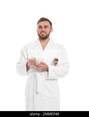 Ein hübscher Mann im Bademantel mit einer Tasse Kaffee auf weißem Hintergrund Stockfoto