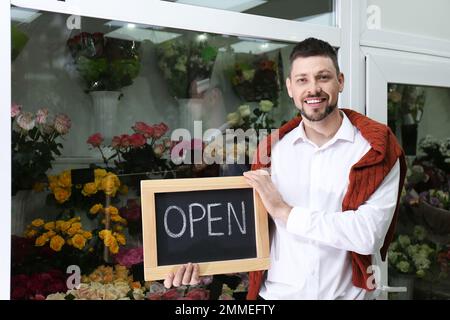 Männlicher Unternehmer mit OFFENEM Schild in seinem Blumenladen Stockfoto