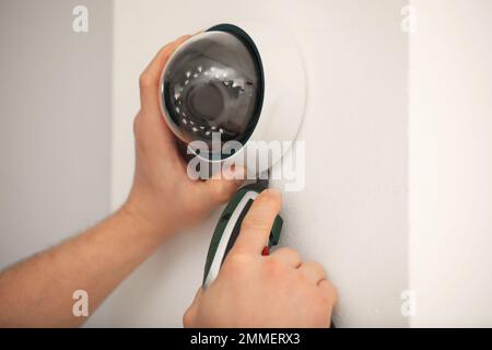 Techniker installiert CCTV-Kamera an der Wand, Nahaufnahme Stockfoto
