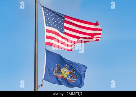 US- und Pennsylvania-Flaggen auf blauem Himmel, Raumbild kopieren Stockfoto