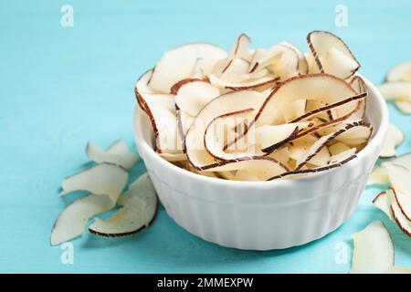 Leckere Kokosnusspäne auf hellblauem Holztisch Stockfoto