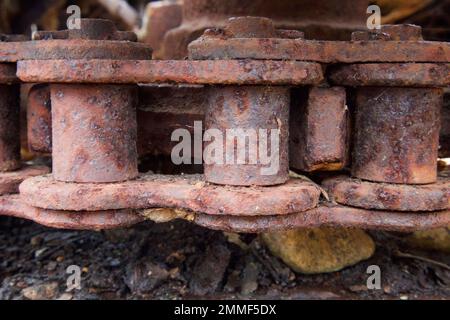 Nahaufnahme eines verrosteten und wetterbedeckten Riemens an alten Maschinen, die in einem Haufen Metallschrott zurückgelassen wurden Stockfoto