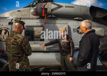 220917-N-GF955-1121 RIGA, Lettland (Sept 17, 2022) U.S. Navy LT. Cmdr. Scott MacDonald, Center, Air Boss von Helicopter Maritime Strike Squadron (HSM) 79, Detachment 2, hebt die Fähigkeiten der MH-60R Sea Hawk-Hubschrauber an John Carwile, rechts, US-Botschafter in Lettland, Und US Marine Corps LT. Col. Greer Chambless, US-Verteidigungsattaché nach Lettland, während einer Tour des Arleigh Burke-Klasse-Lenkraketen-Zerstörers USS Paul Ignatius (DDG 117) in Riga, Lettland, 17. September 2022. Paul Ignatius ist Teil der Kearsarge Amphibious Ready Group und hat 22. Marine Expeditionary Unit unter Th Stockfoto