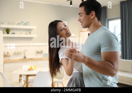 Ein reizendes, junges, gemischtrassiges Paar tanzt zu Hause Stockfoto