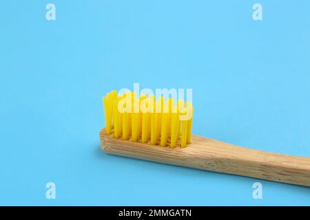 Zahnbürste aus Bambus auf hellblauem Hintergrund, Nahaufnahme Stockfoto