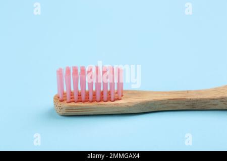 Zahnbürste aus Bambus auf hellblauem Hintergrund, Nahaufnahme Stockfoto