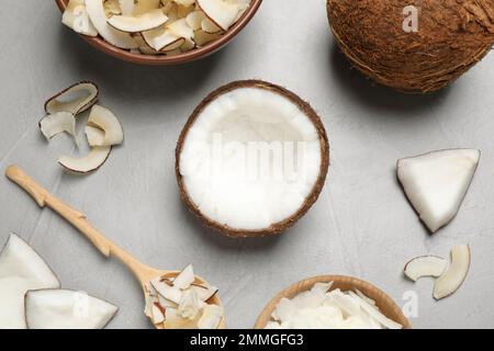 Flache Liegezusammensetzung mit leckeren Kokosnussplittern auf grauem Tisch Stockfoto