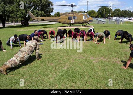 Schüler der Oberschule in Dallas nehmen an einer Push-up-Herausforderung von Rekrutierer und Tourtrainer Sgt. Brandyn Harper Teil, während ihre Tour durch das Armed Forces Center Seagoville am 17. September 2022 endet. Stockfoto