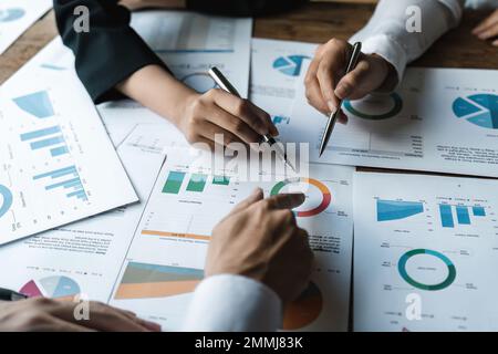 Wirtschaftsdiskussionen, Business-Team analysiert Einkommensdiagramme und -Diagramme, um Marketingkonzepte mithilfe von Computer-Laptop und Taschenrechner zu planen Stockfoto