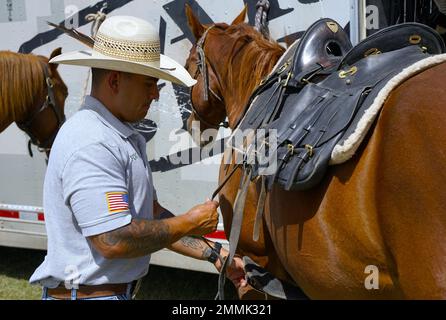 Sgt Vincent Aquino, ein Fort Carson Mountain Color Guard (FCMCG) Soldat, schnallt den Sattel an sein Pferd Sgt. Slim, zur Vorbereitung auf den nationalen Kalvarienwettbewerb 2022 auf dem historischen Wahrzeichen Fort Reno in El Reno, Okla., 20. September 2022. Der Nationale Kalvarienwettbewerb 2022 wird das erste Mal sein, dass dieses Team von FCMCG auf nationaler Ebene antreten wird. Stockfoto